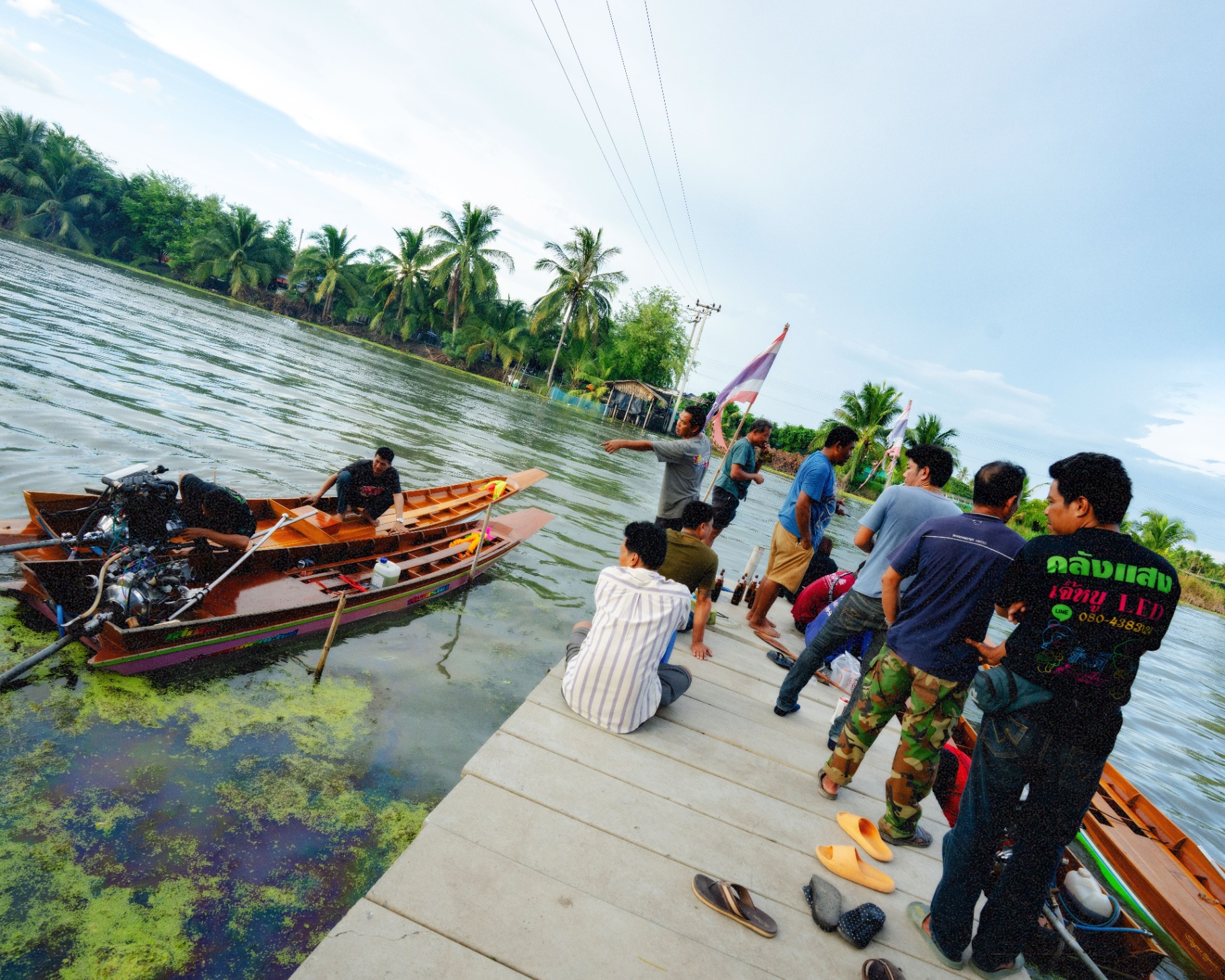 A crew gathers on the dock as a racer preps his engine